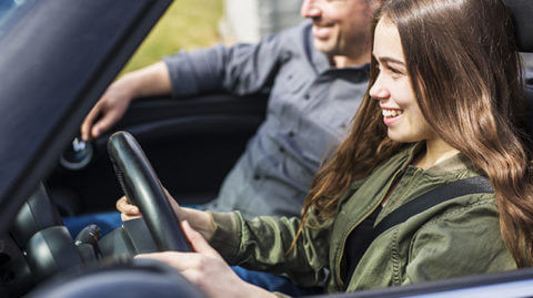 Father teaching teenage daughter how to be a safe driver