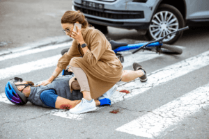 Woman is on the phone next to an injured cyclist. What to do if you get hit by a car. 